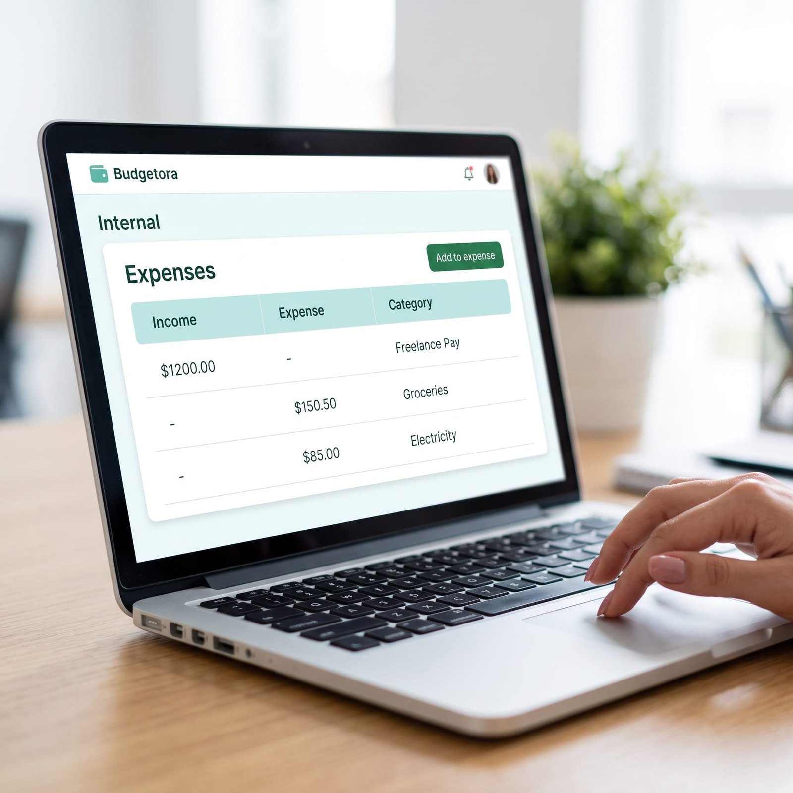 Free monthly budget planner dashboard on laptop tracking freelance income and monthly expenses.
